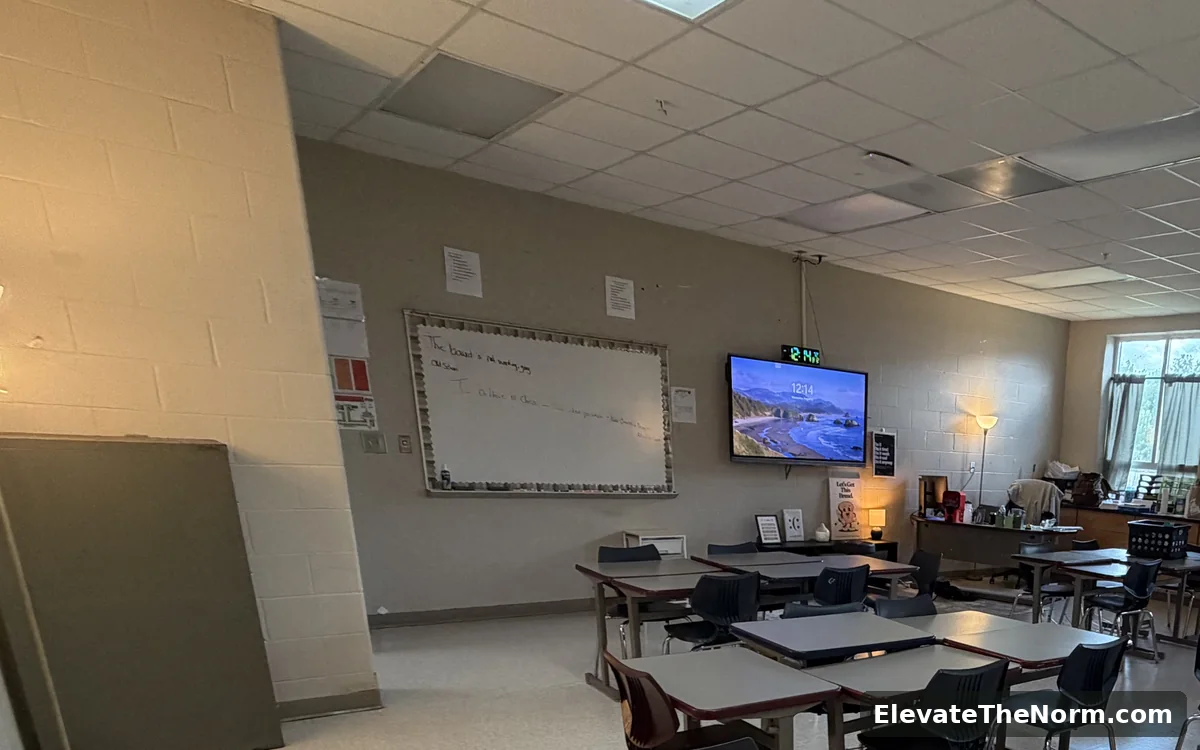 The front wall of the classroom with a whiteboard and a wall-mounted screen showing the time, where the daily plan is posted.